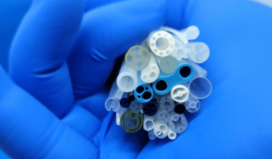 An individual holding a bundle of plastic tubes, displaying a variety of colors and shapes in their grasp.