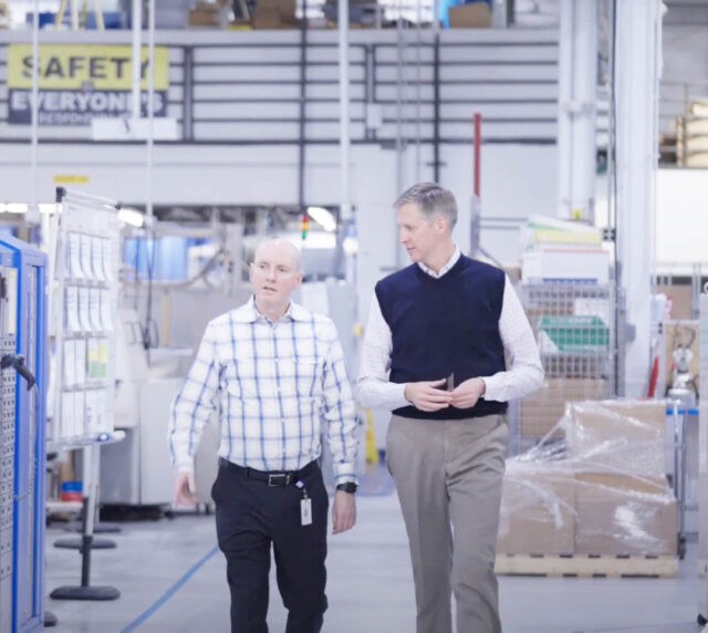 Two professionals walking together in the warehouse.
