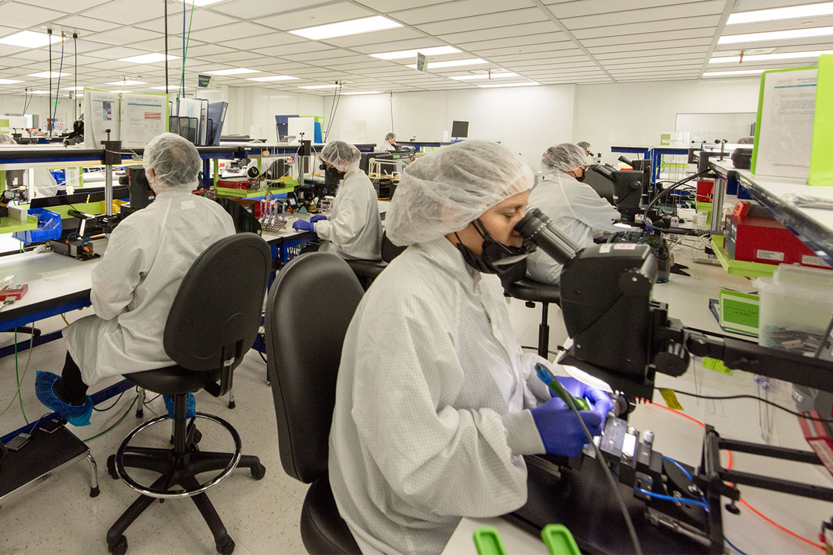 Viant team members in lab coats performing tasks within a lab.