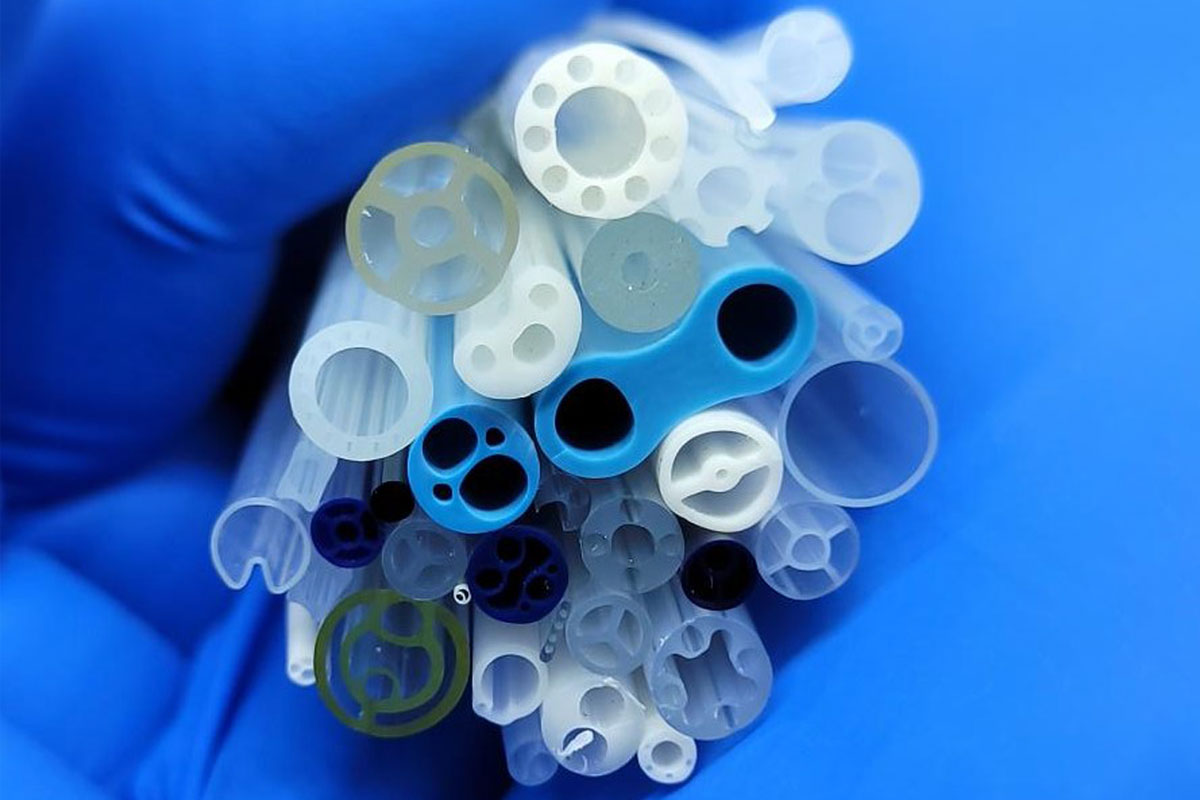 A person grasping a collection of colorful plastic tubes in their hands, showcasing various lengths and sizes.