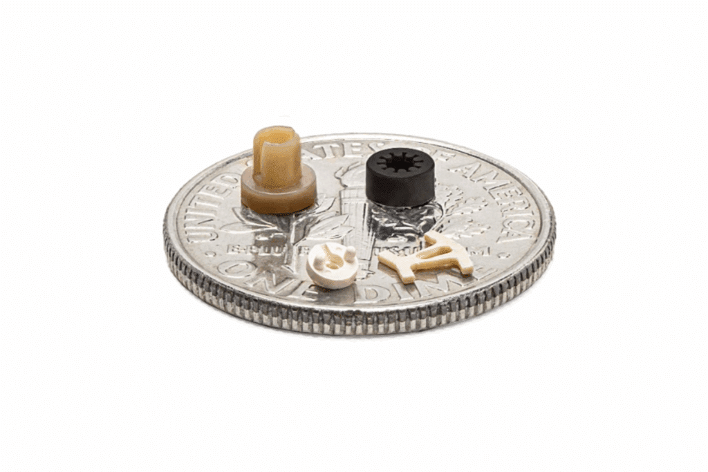 Micromolded plastic components on a dime for scale.